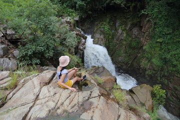 Women enjoying the view of the waterfall in Khlong Wang Chao Kamphaeng Phet National Park, Thailand