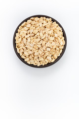 Salty Peanuts in round bowl on white background, top view