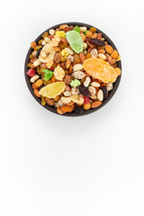 Dried mixed fruits and nuts  in round bowl on white background, top view