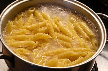 pot with boiling water and Italian pasta during cooking