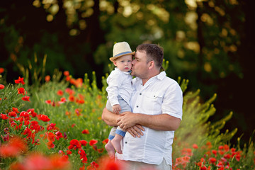 Happy family, father and son at sunset in a poppy field.
