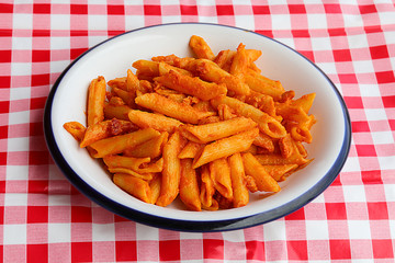 pasta with tomato and cheese on a red and white checkered tablec