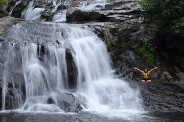 Woman sitting at Khlong Nam Lai waterfall in Klong Lan national park, Kamphaeng Phet, Thailand