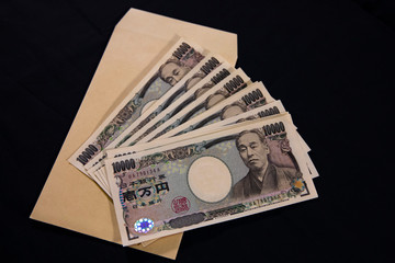 Japanese currency 100,000 yen with envelope on the black background