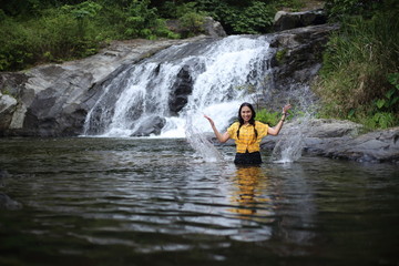 Women enjoying playing in the water at Khlong Nam Lai waterfall in Klong Lan national park, Kamphaeng Phet, Thailand