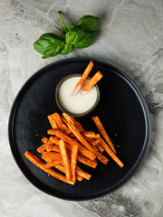 Top view Sweet potato sticks chips appetizer snack served with white sauce. Vegetarian diet and...