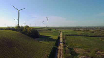Fototapeta premium Wind farm towers surrounded by agricultural fields in Polish country side. Pomerania, Poland.