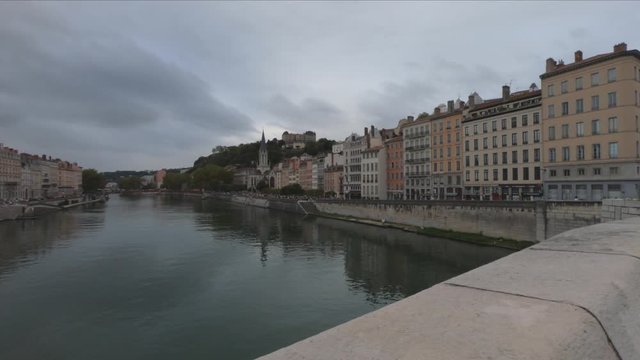 DOLLY SLOW MOTION SHOT - Heading into Vieux Lyon over the Pont Bonaparte. Quai Fulchiron on the banks of the Saone river, Passerelle ,Saint Georges church and Saint-Just College on Fourviere hill.