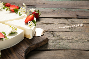 Tasty cheesecake with strawberries on a wooden background. Beautiful composition