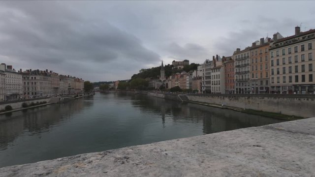 DOLLY SHOT - Heading into Vieux Lyon over the Pont Bonaparte. Quai Fulchiron on the banks of the Saone river, Passerelle ,Saint Georges church and Saint-Just College on Fourviere hill.