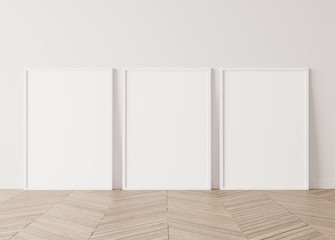 Three white vertical frames Standing on parquet floor with white background, minimal frame mock up interior 
