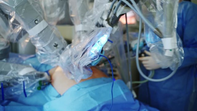 Minimally invasive robotic surgery in operating room. Medical surgical robot doing operation on patient. Hi-tech medical robot.