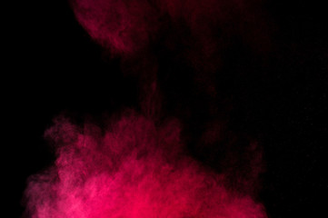 Red and pink powder explosion on black background. Colored powder cloud. Colorful dust explode. Paint Holi.