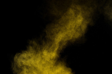 Fototapeta na wymiar Yellow powder explosion on black background. Colored powder cloud. Colorful dust explode. Paint Holi.