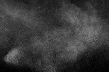 Freeze motion of white particles on black background. Powder explosion. Abstract dust overlay texture.