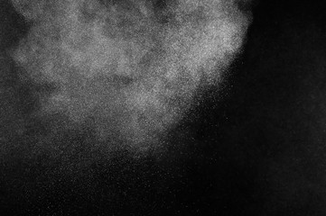 Freeze motion of white particles on black background. Powder explosion. Abstract dust overlay...