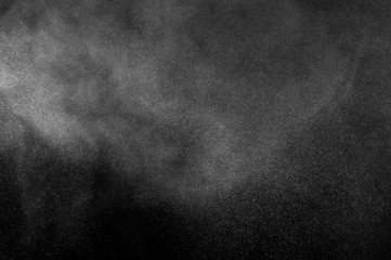 Freeze motion of white particles on black background. Powder explosion. Abstract dust overlay...