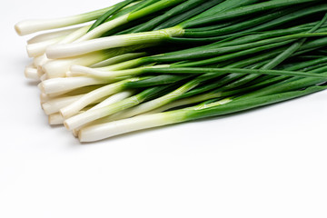 bunch of green fresh onions on a white background