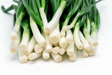 bunch of green fresh onions on a white background