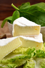 Blue cheese and spinach leaves in a bowl on a wooden kitchen board