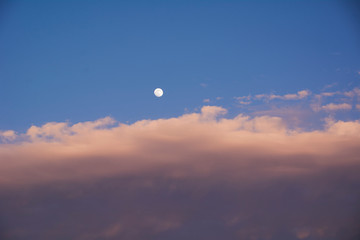 Full moon in blue sky with clouds