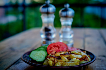 Potatoes, cucumbers and tomatoes on a wooden table.