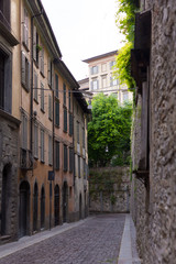 Fototapeta na wymiar Traditional narrow Italian street and no people in Bergamo historical center, Italy. Medieval buildings. There's no one on the street.