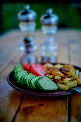 Potatoes, cucumbers and tomatoes on a wooden table.