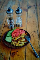 Potatoes, cucumbers and tomatoes on a wooden table.