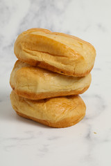 Breakfast buns on white marble background. Sweet brioche