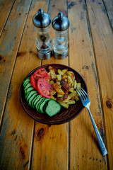 Potatoes, cucumbers and tomatoes on a wooden table.