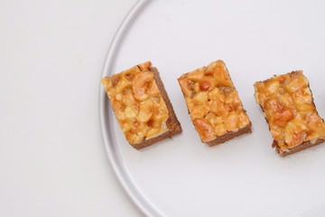 Close up a group of toffee cake pieces top  view  on a plate with white background 