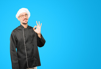 Happy young chef doing an all right gesture
