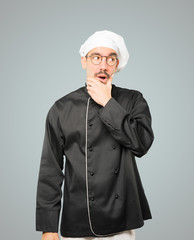 Astonished young chef with a gesture of shock