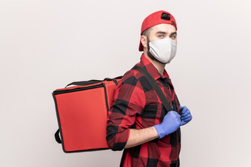 Courier of cafe or restaurant in workwear and protective mask and gloves