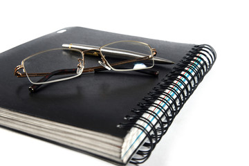 notebook, glasses and pen