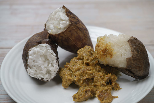 Glutinous rice steamed cooked with coconut milk in pitcher plants known as lemang periuk kera with spicy chicken rendang. A traditional malay cuisine during Hari Raya festival.