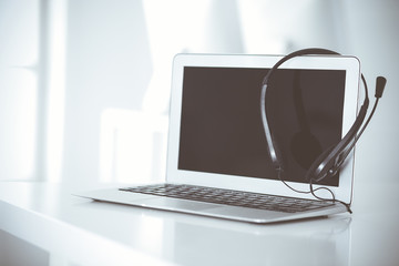 Call center and communication support, customer service help desk. VOIP headset on laptop computer