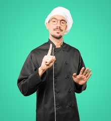 Haughty young chef making a contemptuous gesture