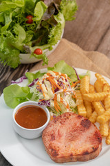 Grilled ham steak with barbecue sauce, side dish salad and french fries on sackcloth. Copy space