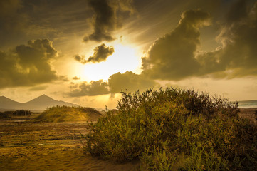 sunset landscape with clouds and sun in the sky of the beach of cofete in Fuerteventura in the Canary Islands