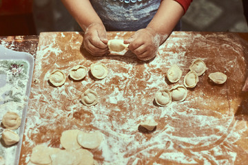 Family concept. Cooking together with children. Little girl leaning how to make manti dumplings. Close up child hands