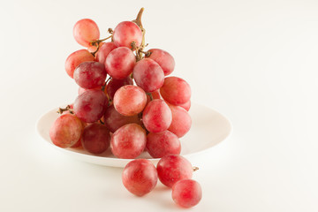 bunch of fresh grapes lies on a dinner plate