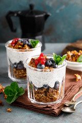 Layered blueberry and red currant parfait with chia yogurt, homemade oat granola and fresh berries for breakfast
