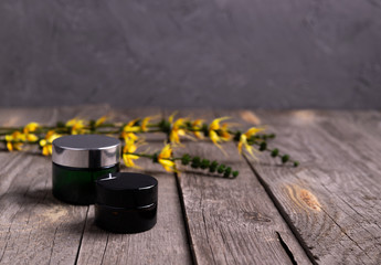 Cosmetics in zero waste eco friendly containers with wildflowers on wooden background