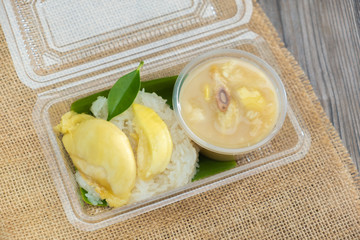 Fresh tasty durian sticky rice with coconut milk on sackcloth ready to eat. Thai style dessert king of fruit. Copy space.