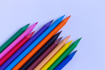 Color pencils on a blue background close-up. Diagonal.space for text