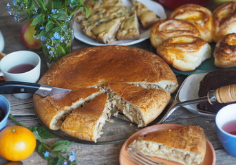 Guest food background.Homemade pie with cabbage and fish on the table with food.