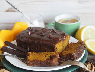 Festive homemade chocolate pumpkin long rectangular cupcake glazed with chocolate. Wooden table.