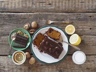 Festive homemade chocolate pumpkin long rectangular cupcake glazed with chocolate. Wooden table.